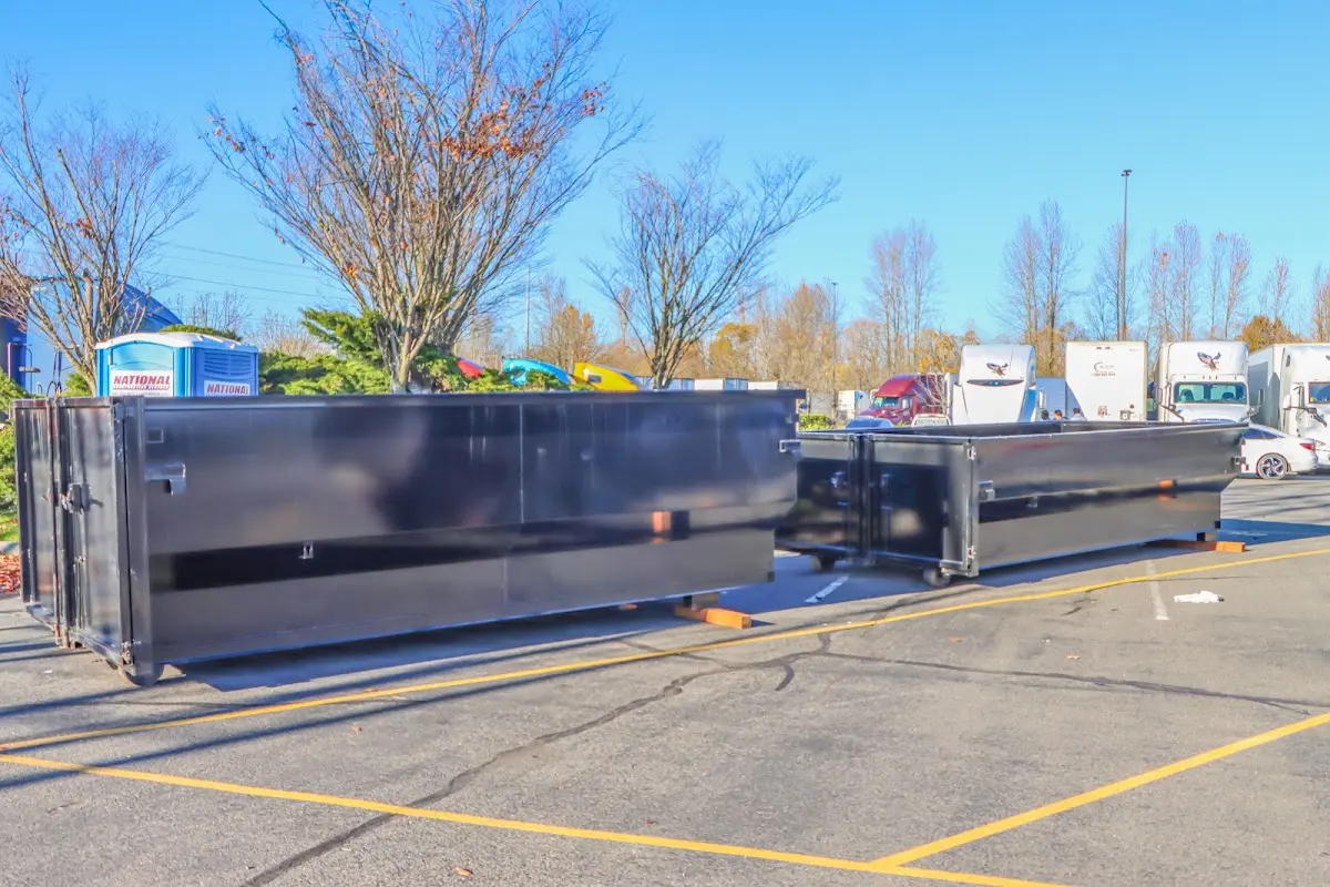 Professional dumpster rental service with roll-off container on residential driveway in Victor